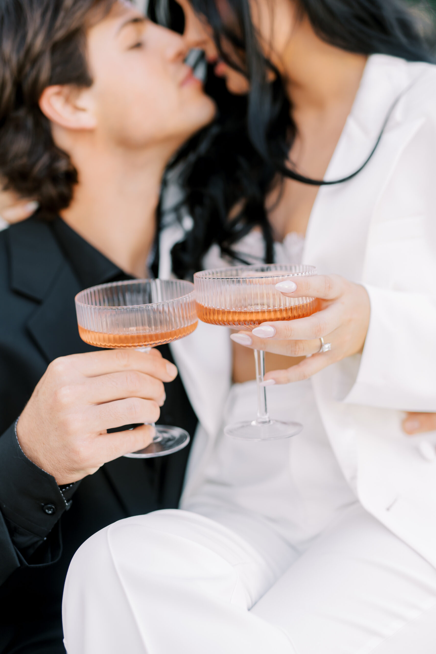 couple shares a glass of champagne at their engagement session