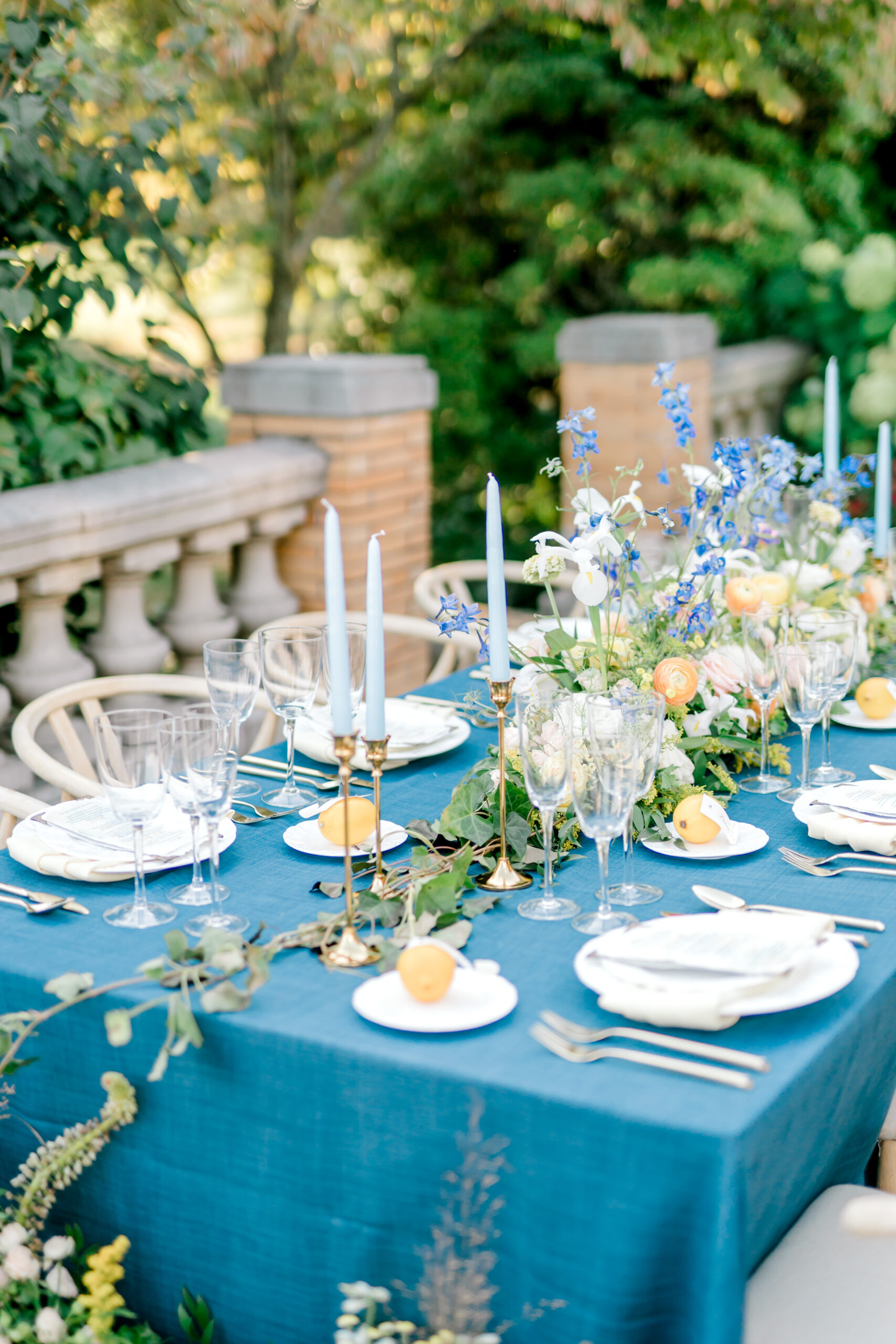 table scape with blue table cloth lemons and wildflowers
