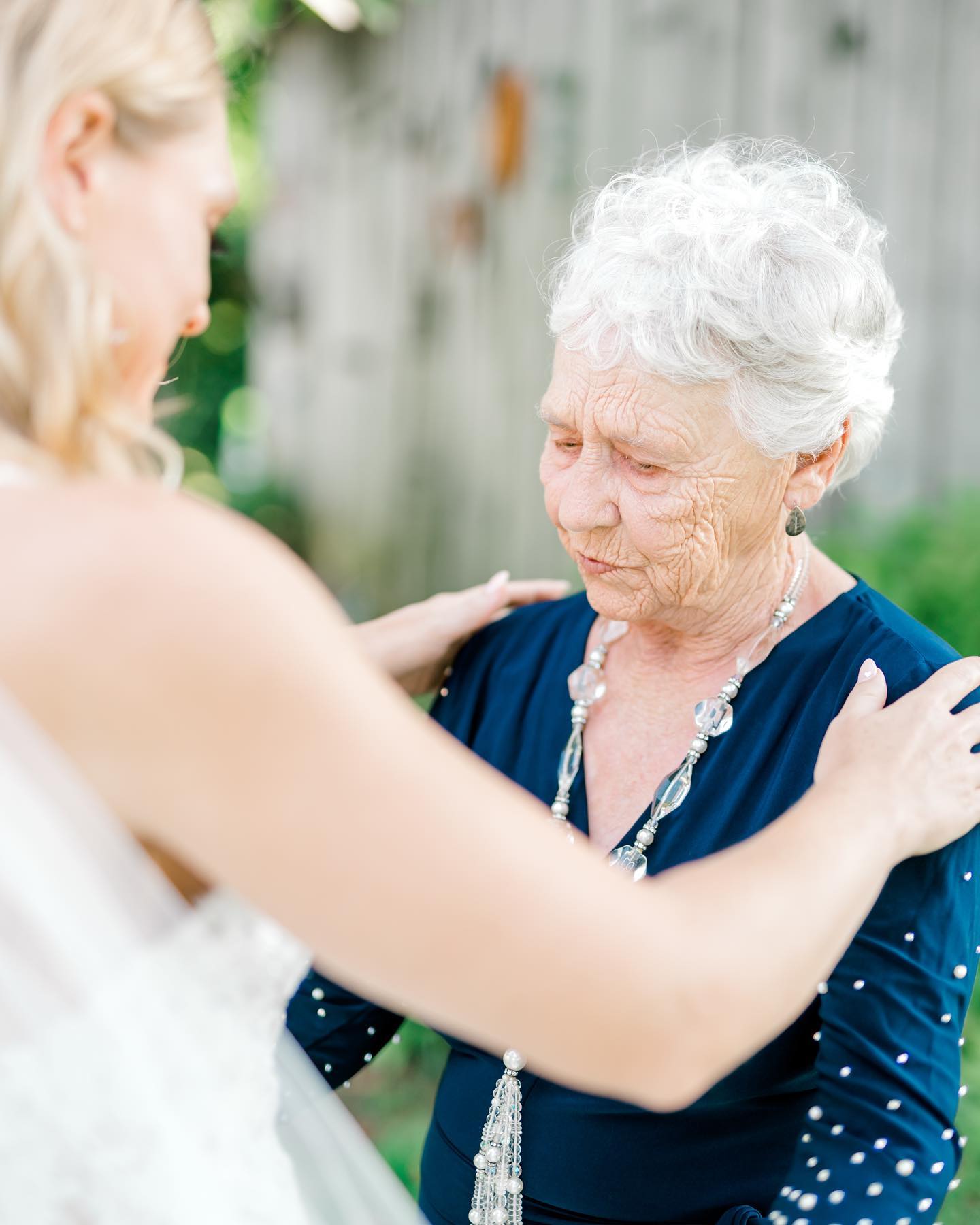 Bride showing her wedding dress to her grandmother