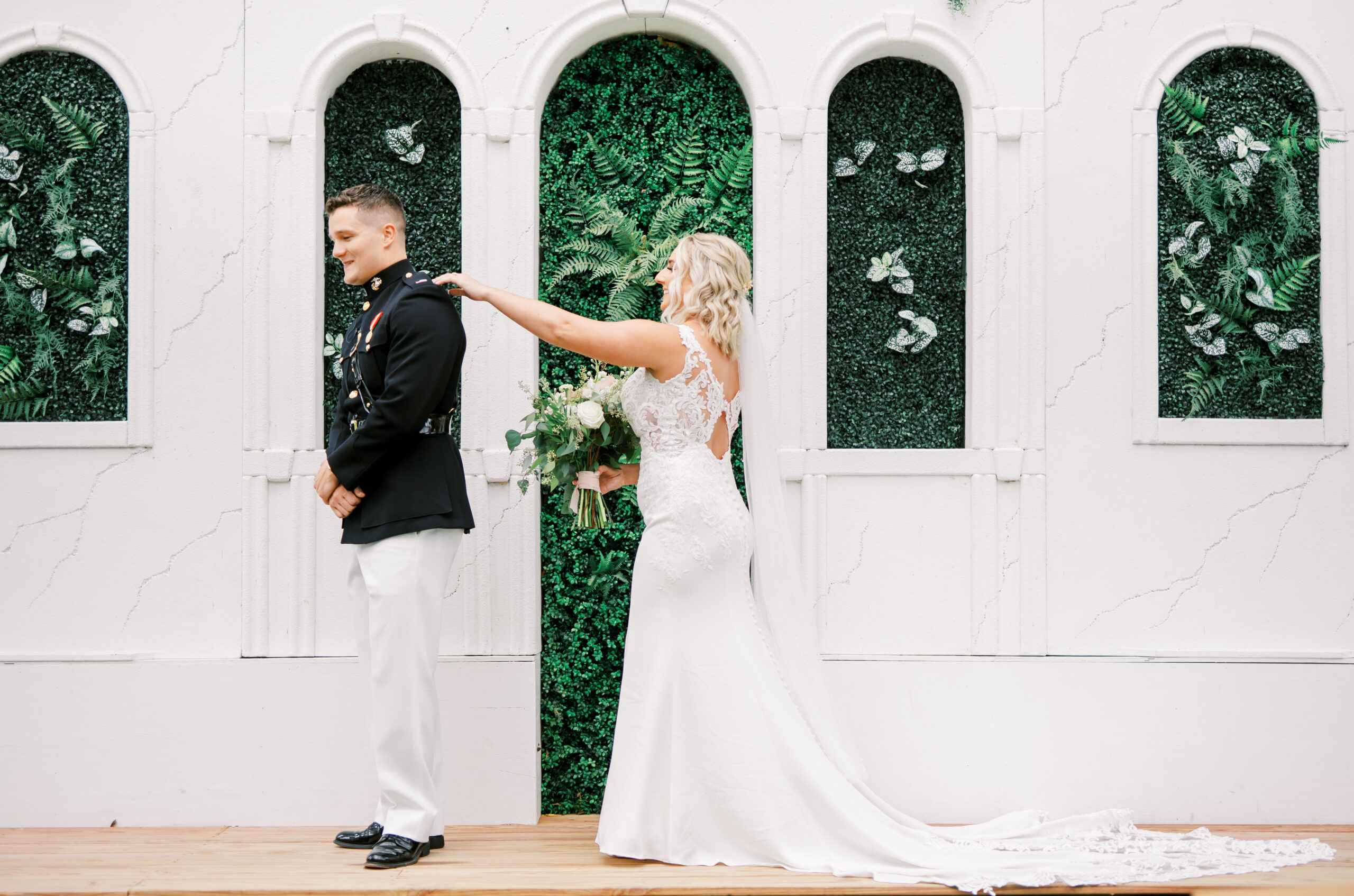Bride tapping military styled groom on his shoulder during their first look